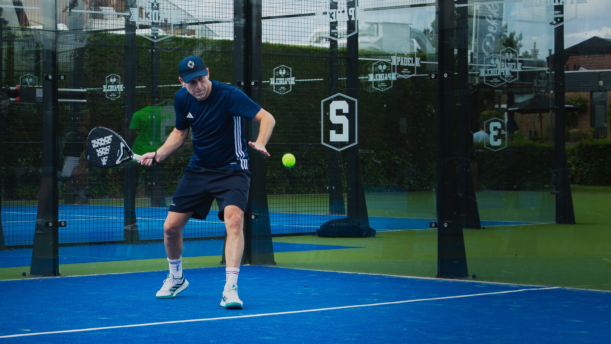 Padelspeler slaat een forehand op een buitenbaan bij Dekker Warmond, padelles in de regio Leiden