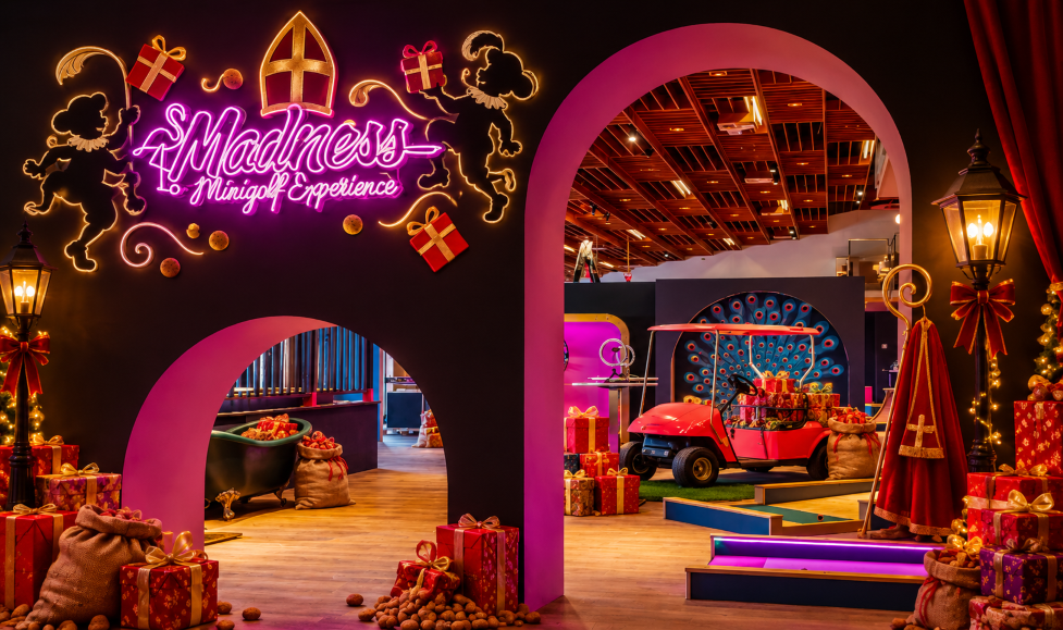 Madness Minigolf Experience bij Dekker Warmond volledig in Sinterklaassfeer, met feestelijke verlichting, cadeautjes, pepernoten, zakken vol lekkers en een vrolijk verlicht Madness-logo.