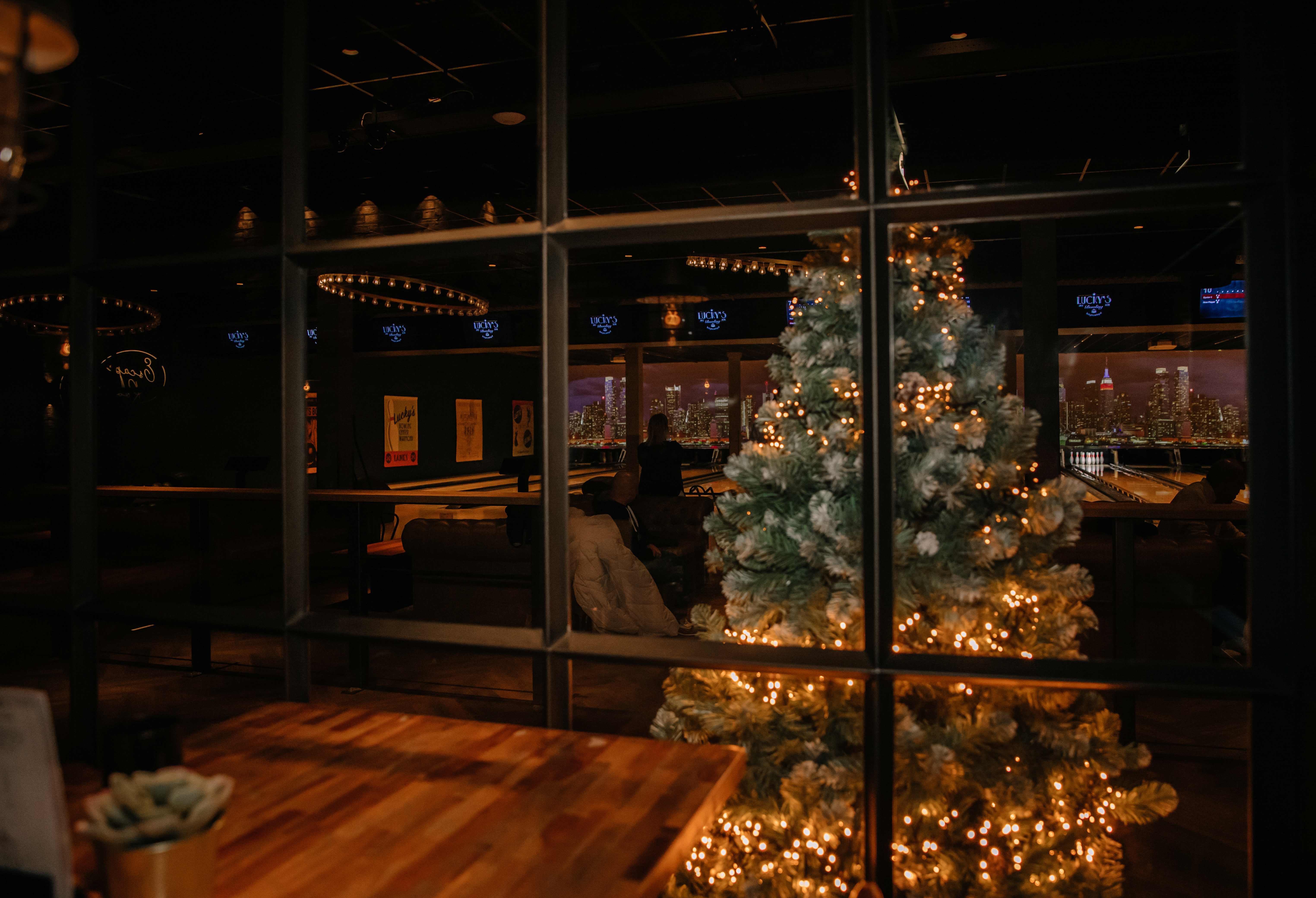 Sfeervolle kerstboom met warme lichtjes bij Lucky’s Bowling in Dekker Zoetermeer. Op de achtergrond zijn de bowlingbanen en gezellige zithoeken te zien.