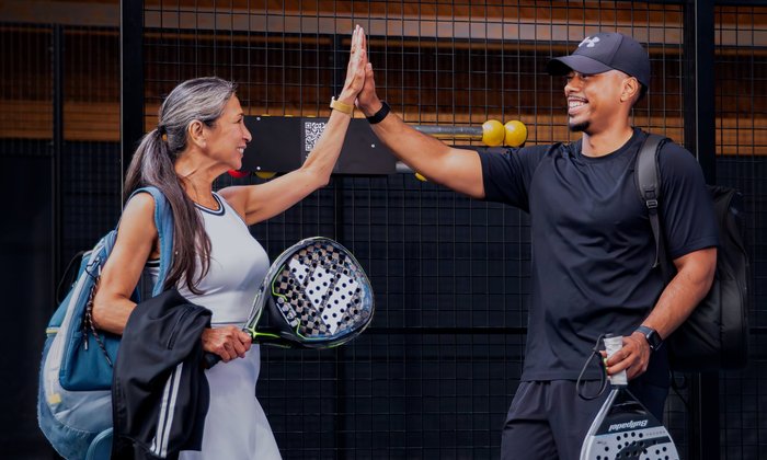 Twee padelspelers geven elkaar een high five na het padellen bij Dekker Warmond